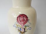 a white vase with a picture of a hot air balloon on it
