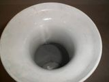 une cuvette de toilette en porcelaine blanche posée sur une table marron
