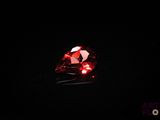 a close up of a red diamond on a black surface