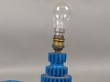 une ampoule bleue posée sur un engrenage bleu