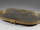 an oval brass tray with handles and handles on a white surface