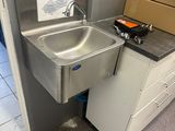 a sink in the corner of a room with a box on the floor