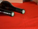 two bottles of wine sitting on a red cloth