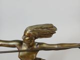 bronze statue of a woman with a bow and arrow on a wooden table