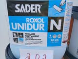 a plastic container with a sticker on it next to two cans of paint