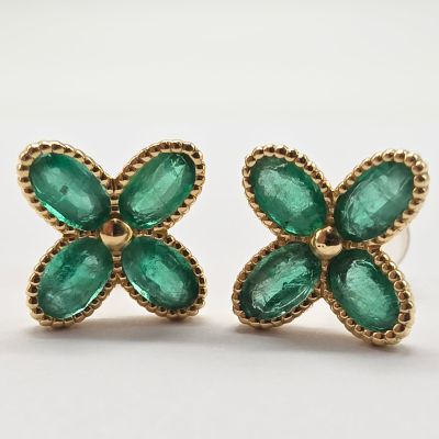 une image représentant une paire de boucles d'oreilles émeraude sur fond blanc
