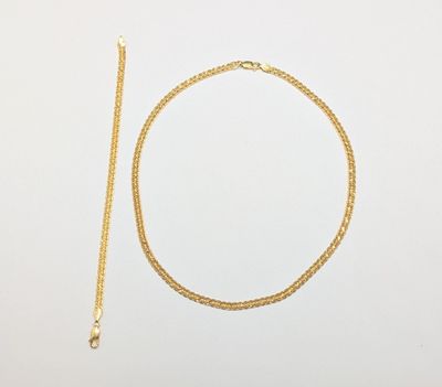 un collier en or et une chaîne en or sur fond blanc