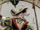 a clock with a statue of a man holding a staff