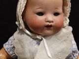 a small doll that is wearing a bonnet and dress