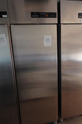 trois réfrigérateurs en acier inoxydable dans la cuisine, sur lesquels sont apposées des étiquettes