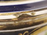 a close up of a blue vase with gold trim