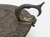 a silver plate with a fish on it on a white surface