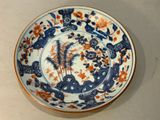 une assiette bleue et blanche ornée de motifs orange