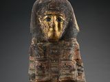 un masque égyptien antique peint en doré sur fond noir
