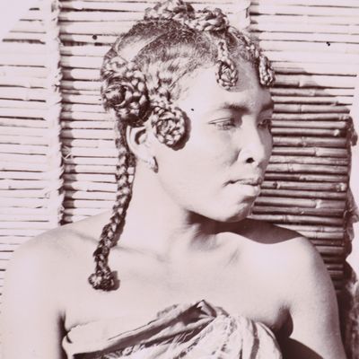 une vieille photo en noir et blanc d'une femme aux cheveux tressés