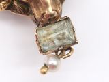 an image of a close up of a broochle of a goat with a stone