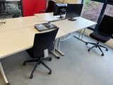 a white table with two black chairs and a laptop on it