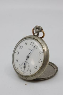 a silver pocket watch sitting on top of a coin