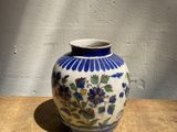 un vase bleu et blanc posé sur une table en bois