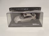a white toy car in a clear box on a table