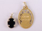 an image of a gold pendant with a black stone in the center