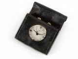 a small clock in a black case on a white surface