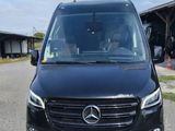 the front view of a black mercedes van parked in a parking lot