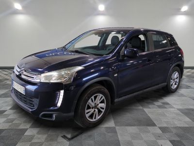 un 4x4 bleu garé dans une pièce au sol en damier