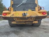 a back end view of a large yellow truck parked on the side of the road