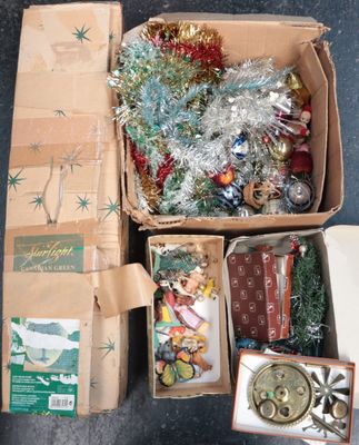 une boîte remplie de décorations de Noël et d'autres objets, posée par terre