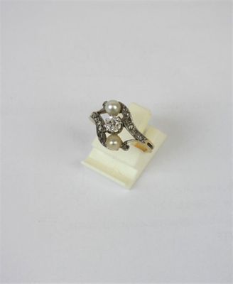 a close up of a diamond and pearl ring on a white surface