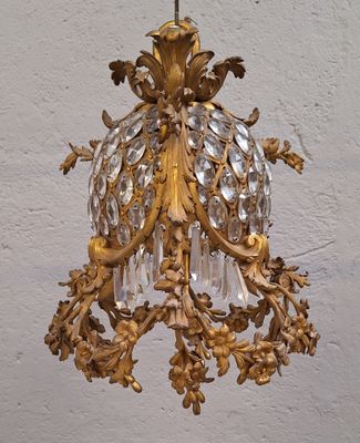 un lustre doré suspendu à un mur blanc