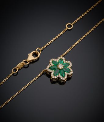 un pendentif en forme de trèfle, serti d'une émeraude et de diamants, monté sur une chaîne en or