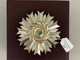 une petite boîte ornée d'une médaille, posée sur une table