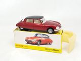 une petite voiture rouge posée sur une boîte jaune