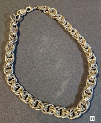 a close up of a silver chain necklace on a table