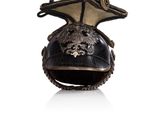 an old helmet with a dragon on top of it on a white surface