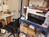 a desk with a printer and a chair in a room