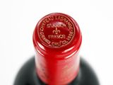 a close up of a bottle of wine on a white surface