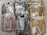 four bags of clothing wrapped in plastic on a shelf