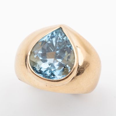 an image of a gold ring with a blue topazt stone
