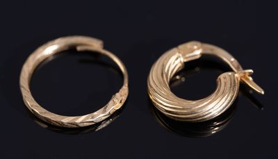 une paire de boucles d'oreilles en or sur une surface noire