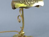 brass plated desk lamp with a gold colored shade and a gold colored base