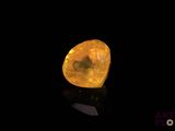 a yellow diamond on a black surface with a black background