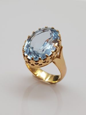 a close up of a ring with an oval blue topaz stone