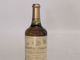 une vieille bouteille de vin posée sur une table blanche
