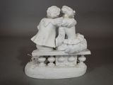 une statue représentant deux enfants assis sur un banc