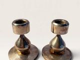 pair of brass candlesticks on a white background
