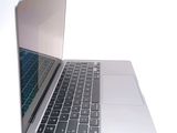 a silver laptop with a blue keyboard on a white surface