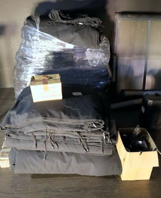 a pile of clothes and a box of bottles on a table